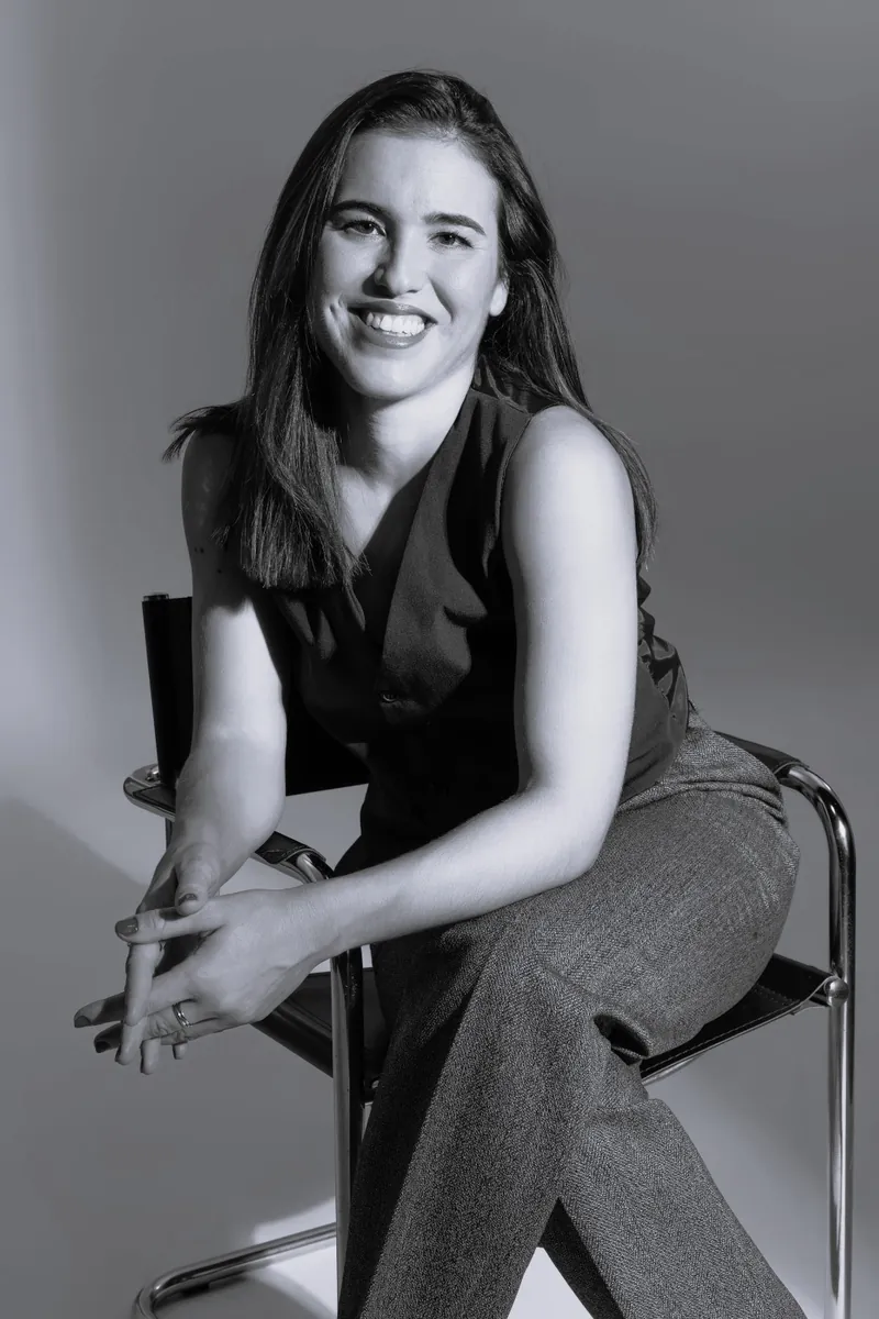 Retrato en blanco y negro de Ana García, arquitecta, sentada en una silla de tubo cromado