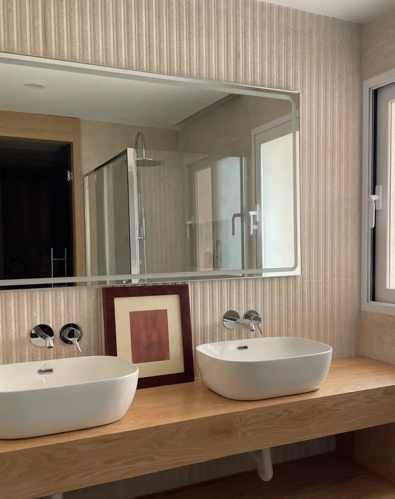 Baño del dormitorio principal con doble lavabo y espejo retroiluminado